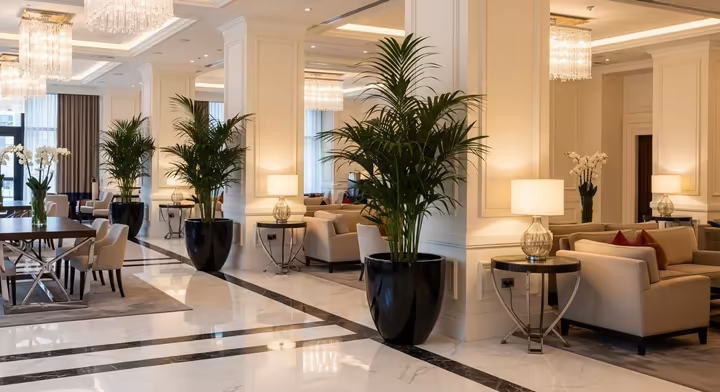 A wide-angle view of a modern and luxurious hotel lobby with plush seating, warm lighting, and a feeling of calm elegance.