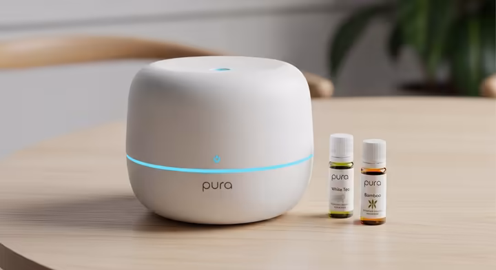 The Pura smart home diffuser shown with two fragrance vials, suggesting a variety of hotel-like scent options.